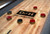 Detailed top view of George Shuffleboard Table in Natural Ash by Doc & Holliday highlighting wood grain playfield, scoring markers, and professional shuffleboard pucks.