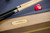 Close-up of the Plank & Hide Deco name plate on the Glazed Maple pool table with golden brass accents.
