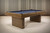 Plank & Hide Co Plank & Hide Deco 8' Slate Pool Table in Glazed Maple, modern billiards table with sleek wooden finish against a textured wooden wall.