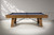 Plank & Hide Co Isaac 8' Slate Pool Table in Glazed Maple, modern billiards table with wooden frame and slate top, placed in a bright room with white walls and soft shadows.
