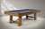Plank & Hide Co Isaac 8' Slate Pool Table in Glazed Maple, a stylish wooden billiards table with a slate playing surface, situated in a modern, well-lit room.