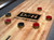 Detail view of the Derby shuffleboard table scoring area on the maple butcher block playfield with professional shuffleboard pucks.