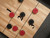 Doc & Holliday Derby Shuffleboard Table in Walnut, top view of a shuffleboard game with red and black pucks on a wooden court with black scoring lines and numbers