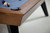 Doc & Holliday The Bellano Slate Pool Table in Matte Brandwine, close-up of the wooden corner and pool balls on the blue felt surface.