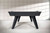 Doc & Holliday The Bellano Slate Pool Table in Matte Black, modern pool table with sleek black finish and stylish angled legs, set against a textured concrete wall.