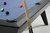 Doc & Holliday The Bellano Slate Pool Table in Matte Black, close-up view showing the pool table with billiard balls and cue sticks.