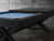 Doc & Holliday Portland 8' Slate Pool Table in Black Ash, modern design with a black ash wood finish and a blue felt playing surface set against a concrete wall background.