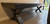 Sawyer Twain Maverick Shuffleboard Table, modern shuffleboard with black surface and metal X-shaped legs, positioned near a sliding glass door in a contemporary home.