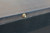 Plank & Hide Co Otis Slate Pool Table Smokehouse, close-up of a brass bolt on the black textured edge of the pool table.
