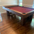 Playcraft BullRun 8' Slate Pool Table - | Rustic Timber Frame, image of a rustic wooden pool table with red felt, sturdy timber frame, and a wooden playing surface, in a well-lit game room.