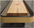 Venture Shuffleboard Classic Shuffleboard Table by Venture, handcrafted in USA, showing a close-up view of the wooden playing surface with score markings and a black border edging.