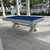 Sawyer Twain X-Air 8' Outdoor Slate Pool Table, white modern pool table with blue felt on a patio with poolside gazebo and palm trees.