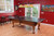Sawyer Twain Convertible Table Tennis Top, a ping pong table with a black surface and wooden legs, set up in a game room with red walls, bar stools, and colorful decor.