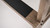 Plank & Hide Co Spectator Chair, close-up view of the wooden armrest with black metal detail and screws.