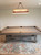Sawyer Twain Powell 8' Pool Table with Premium Accessories, featuring a wooden frame, dark finish, and sleek design, positioned in a spacious game room.