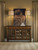 Hooker Furniture Tynecastle Buffet, a wooden sideboard with glass-paneled doors and metal handles, placed against a beige wall with a large dog portrait hanging above it, flanked by two brass table lamps.
