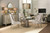 Hooker Furniture Elixir Buffet, a luxurious modern dining room featuring an elegant glass-top table surrounded by cream upholstered chairs, with a stylish sideboard, decorative lamps, and contemporary wall art.