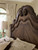 Hooker Furniture Rhapsody King Panel Bed, detailed view of the intricately carved wooden headboard with scrollwork and a polished finish.