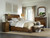 Hooker Furniture Archivist Queen Sleigh Bed w/Low Footboard, elegant wooden bed with curved sleigh design, in a cozy bedroom with natural light, beige bedding, and classic decor.
