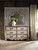 Hooker Furniture Chatelet Dresser II, vintage distressed cream-colored dresser with six drawers and ornate bronze handles, featuring a decorative curved mirror attached to the top, in a classic elegant bedroom setting.