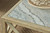 Hooker Furniture Surfrider Square Cocktail Table, close-up of the table's marble top with a woven basket containing coral decoration on it.