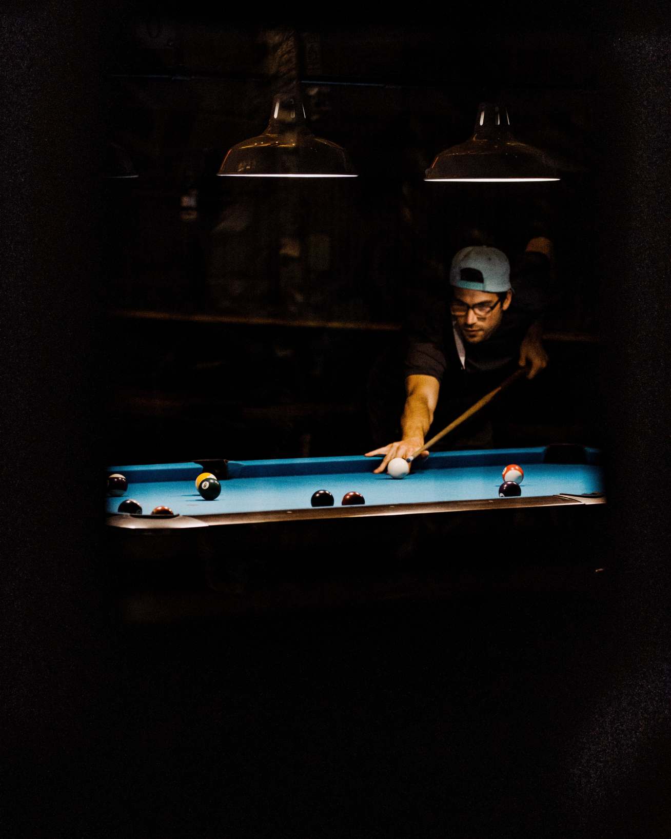 Man at blue and brown billiards table practicing to get better at pool