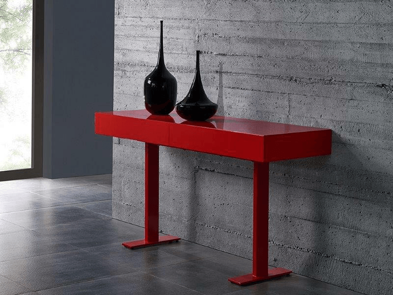 red living room console against a cement interior wall with black vases on it