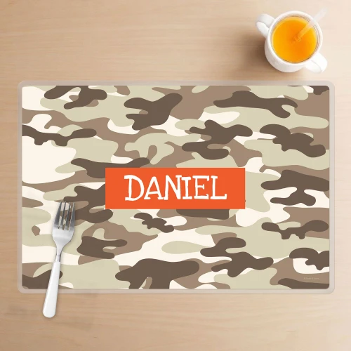 Spark & Spark Brown Camouflage Kids Placemats, personalized camouflage-themed placemat with the name Daniel on it, placed on a wooden table with a fork and a glass of orange juice.