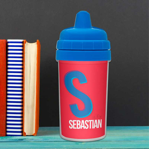 Spark & Spark Double Initial Red Sippy Cup, pink sippy cup with a blue lid and large letter 'S' on the front, personalized with the name 'Sebastian'.