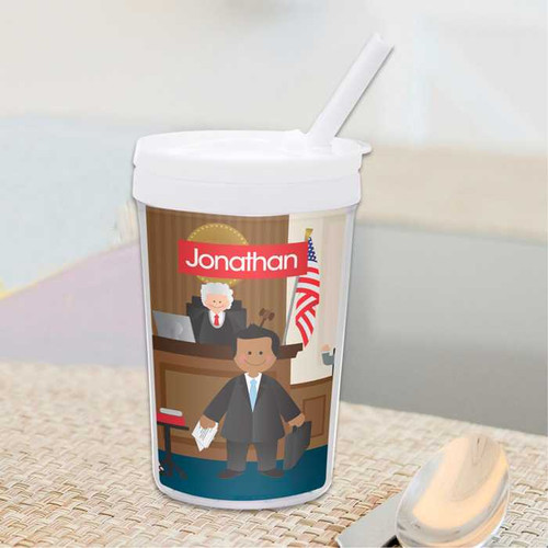 Spark & Spark Legally Correct Boy Toddler Cup, illustrated toddler boy dressed as a lawyer holding a briefcase and file, with a judge in a courtroom background and American flag.