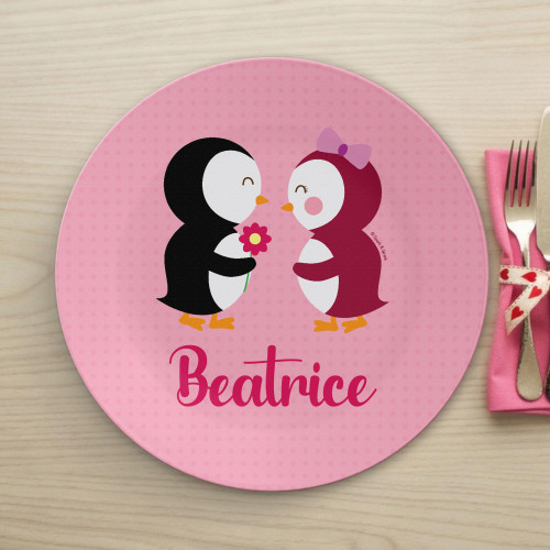 Spark & Spark Penguins in Love Kids Placemat featuring a cute illustration of two penguins, one holding a flower, on a pink background with the name Beatrice written below.
