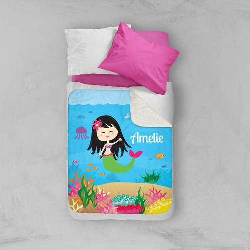 Spark & Spark Sweet Mermaid Sherpa Blanket on a bed, featuring a colorful underwater scene with a smiling mermaid, custom name 'Amelie', and vibrant coral and sea life.