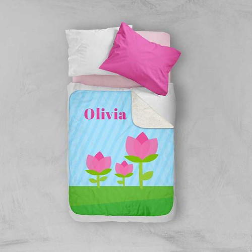 Spark & Spark Cute Tulip Sherpa Blanket, personalized blanket featuring pink tulip flowers and the name Olivia on a light blue background with green grass.