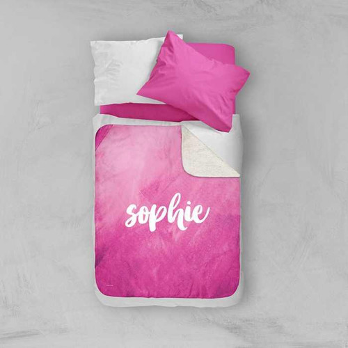 Spark & Spark Bold Colorful Name Pink Sherpa Blanket, personalized pink sherpa blanket with the name 'Sophie' written on it, displayed on a bed with pink and white pillows.