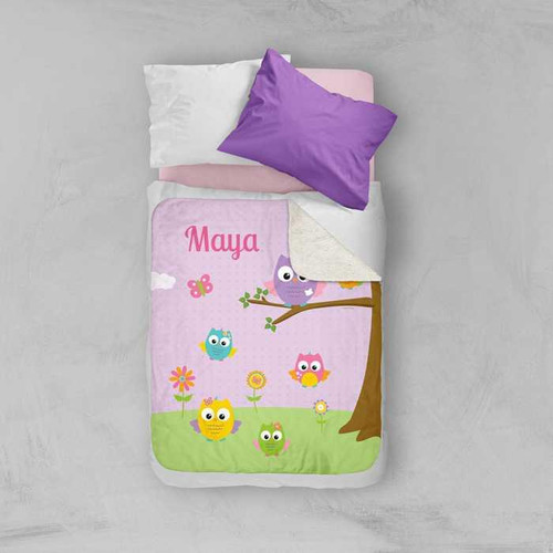 Spark & Spark Owls on the Field Sherpa Blanket, colorful blanket with owl and floral design on a child's bed with pillows.