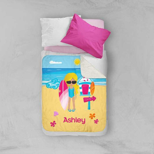 Spark & Spark Beach Girl Sherpa Blanket, colorful beach-themed blanket with a girl in sunglasses holding a surfboard on a sandy beach with the name Ashley below.