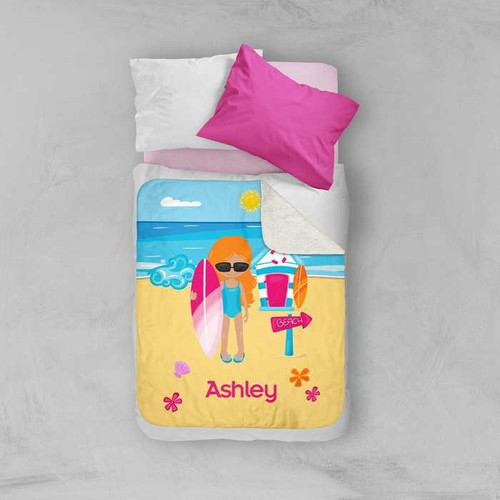 Spark & Spark Beach Girl Sherpa Blanket, colorful illustrated beach scene with a girl holding a surfboard, on a bed with pink, white, and purple pillows.