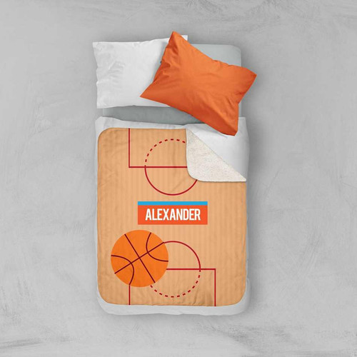 Spark & Spark Basketball Fan Sherpa Blanket, orange basketball-themed design on a bed with pillows.