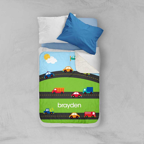 Spark & Spark My Commute Sherpa Blanket, colorful road and vehicle design with the name 'brayden' on the blanket, on a bed with pillows.