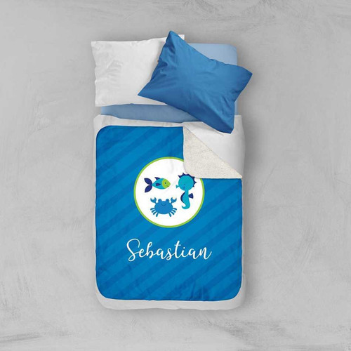 Spark & Spark Cute Undersea Creatures Sherpa Blanket, blue blanket with sea animal designs and a personalized name 'Sebastian' on it, laid out on a bed with pillows.