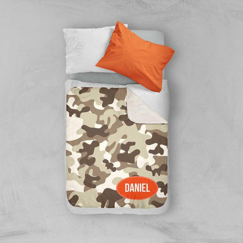 Spark & Spark Brown Camouflage Sherpa Blanket, a cozy camouflage patterned sherpa blanket with a personalized name 'DANIEL' embroidered on it, displayed on a bed with pillows.