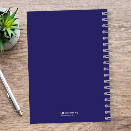 SparkGreetings® Simply Dots Writing Journal, blue spiral-bound notebook on wooden desk with a pen and a potted succulent plant