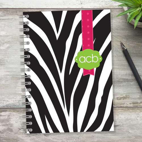 SparkGreetings® Zebralicious Writing Journal, a black and white zebra print notebook with a pink polka dot ribbon and green 'acb' label on the cover.