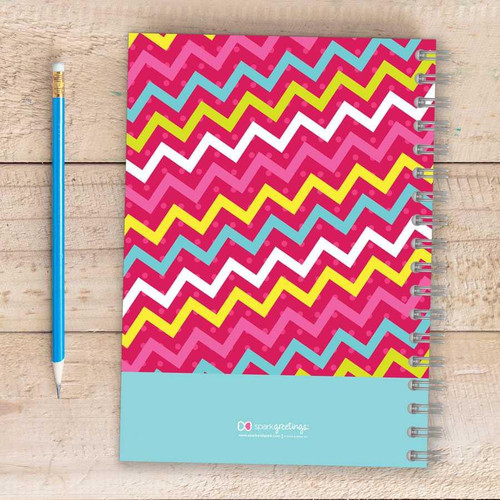 SparkGreetings® Mix Chevrons Writing Journal, colorful chevron pattern with pink, blue, yellow, and white zigzags on cover with spiral binding on the right side.