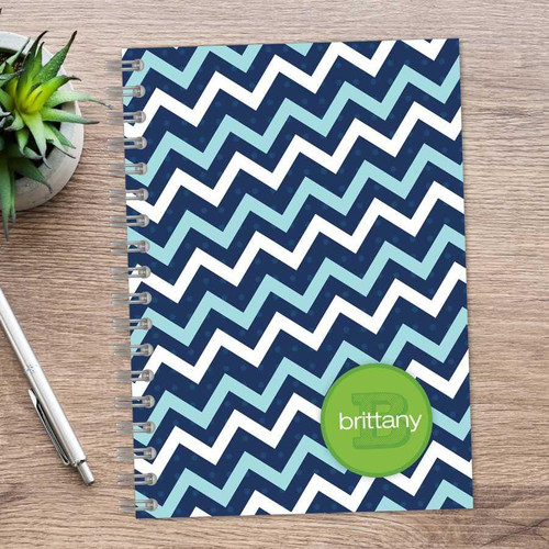 SparkGreetings® Mod Chevrons Writing Journal, spiral-bound notebook with a blue and light blue chevron pattern cover on a wooden surface.