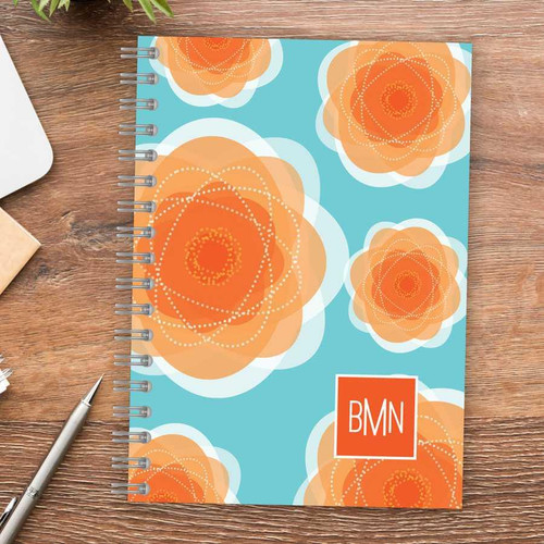 SparkGreetings® Pretty Blooms Writing Journal with orange floral design on a blue background, featuring a red and white BMN logo in the bottom right corner.