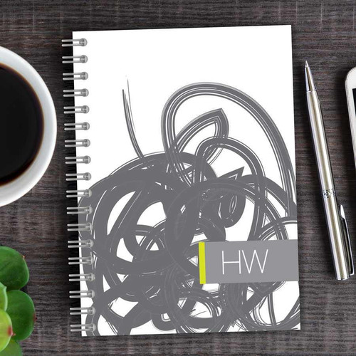 SparkGreetings® Urban Graffiti Writing Journal, spiral-bound journal with abstract graffiti design on the cover, placed on a wooden desk next to a cup of coffee and a silver pen.