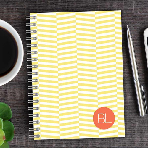 SparkGreetings® Up and Down Style Writing Journal, yellow and white chevron patterned spiral-bound notebook with an orange circle containing 'BL' on the cover.