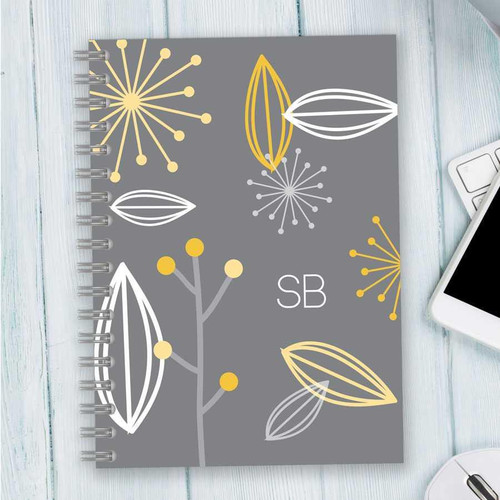 SparkGreetings® Deconstructed Nature Writing Journal, stylish gray journal with yellow, white, and gray botanical-themed abstract leaf and flower designs, monogrammed with initials SB on the cover.