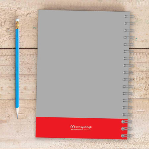 SparkGreetings® Bike Ride Writing Journal, gray and red spiral-bound notebook with a blue pencil on a wooden surface.
